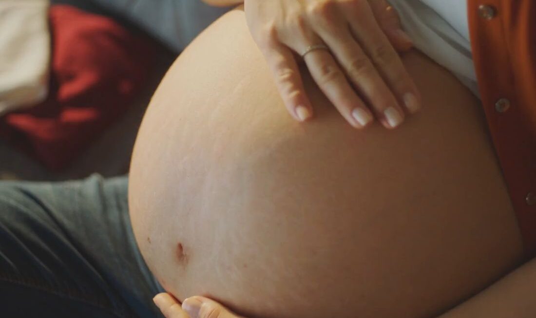 devojka se drži za trudnički stomak